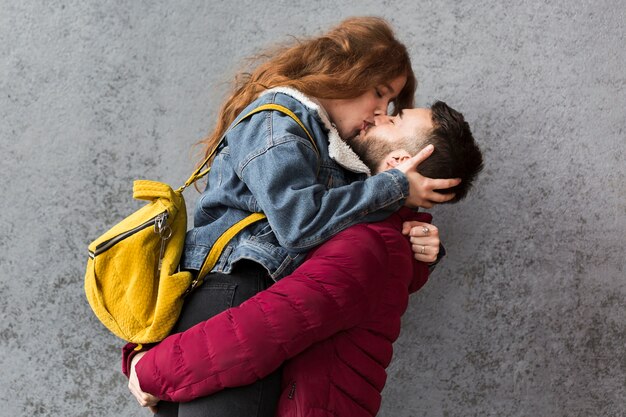 Hombre besando a su mujer tiro medio