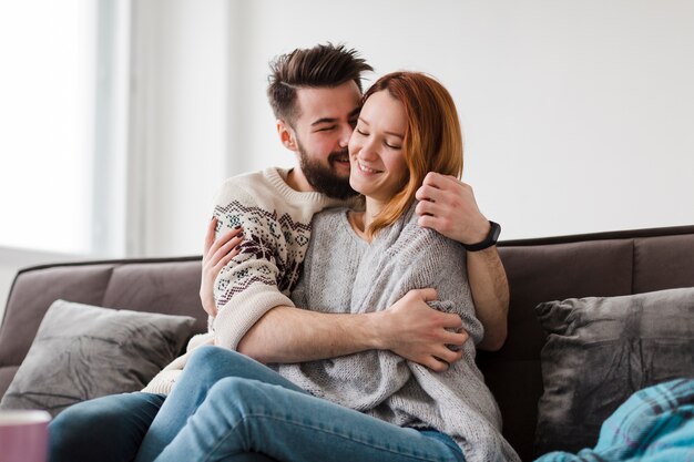 Hombre besando a su novia en la sala de estar