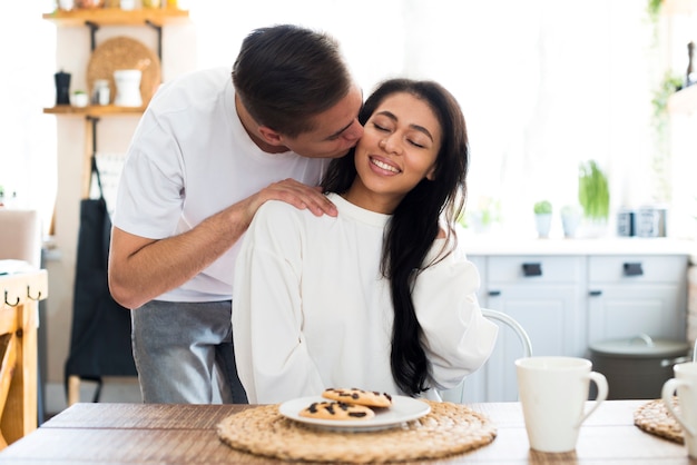 Foto gratuita hombre besándose en la mejilla étnica joven novia