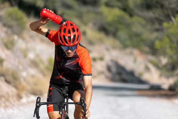 Foto gratuita hombre en bicicleta al aire libre con su bicicleta y casco