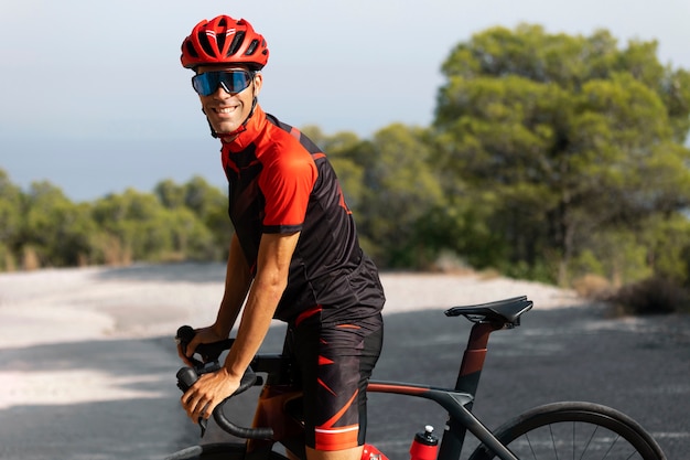 Hombre en bicicleta al aire libre con su bicicleta y casco