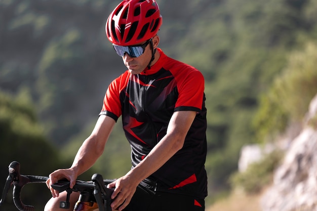 Foto gratuita hombre en bicicleta al aire libre con su bicicleta y casco