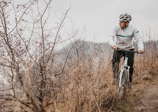 Foto gratuita hombre en bicicleta de montaña en equipo especial con espacio de copia