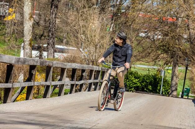 Hombre en bicicleta por el puente de madera y disfrutando de su viaje