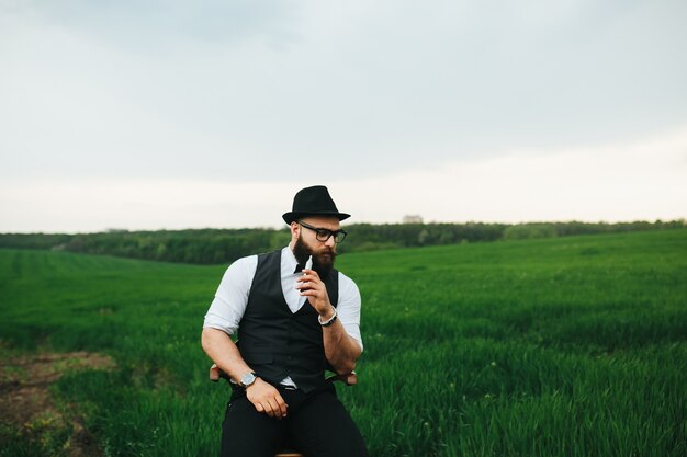 Hombre bien vestido fumando cigarrillo electrónico