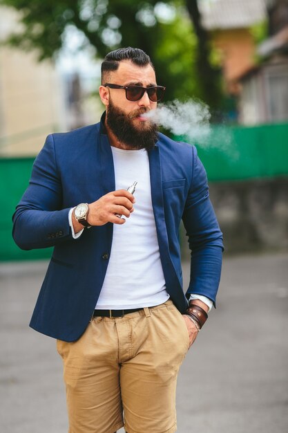 Hombre bien vestido fumando cigarrillo electrónico