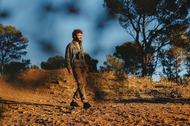 Hombre con binoculares caminando en la naturaleza