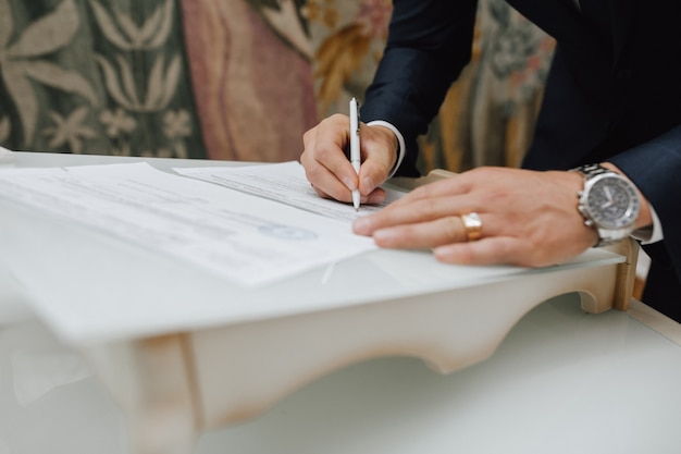 Hombre con un bolígrafo firma un documento