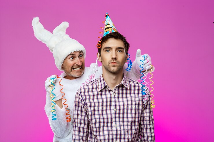 Foto gratuito hombre borracho y conejo en la fiesta de cumpleaños sobre la pared púrpura.