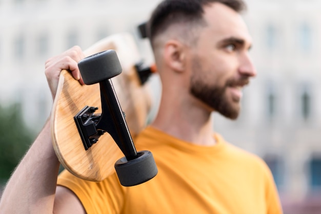 Foto gratuita hombre borroso sosteniendo una patineta