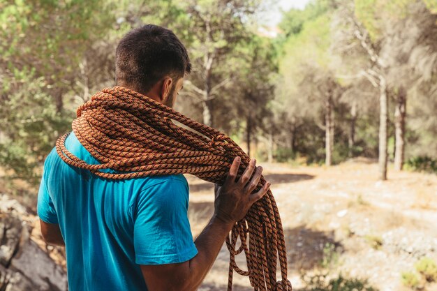 Hombre en bosque con cuerda por el cuello