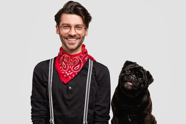 Hombre brunet elegante vestido con pañuelo rojo junto al perro