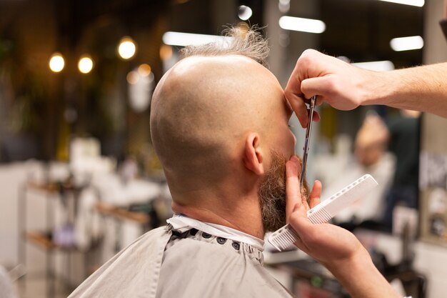 Hombre brutal europeo con barba cortada en una barbería