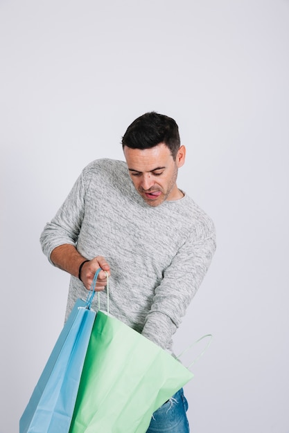 Hombre buscando en bolsa de compras