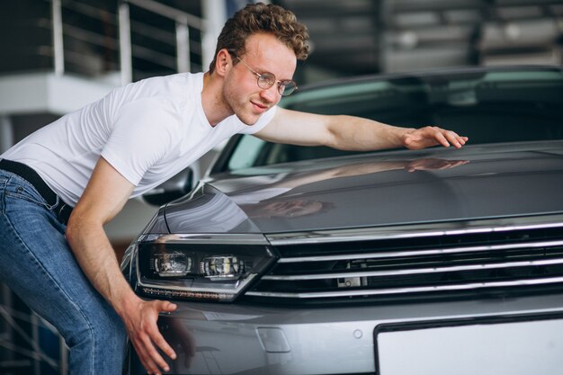 Hombre buscando un coche en una sala de exposición de coches.