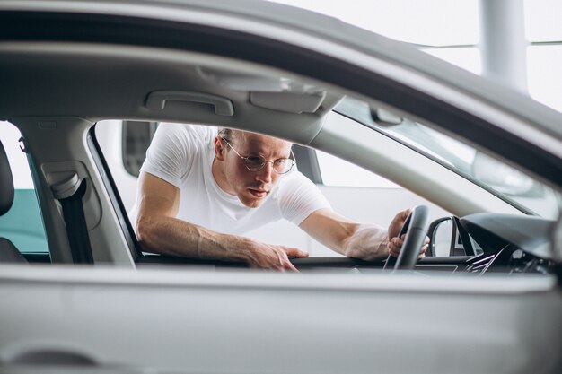 Hombre buscando un coche en una sala de exposición de coches.