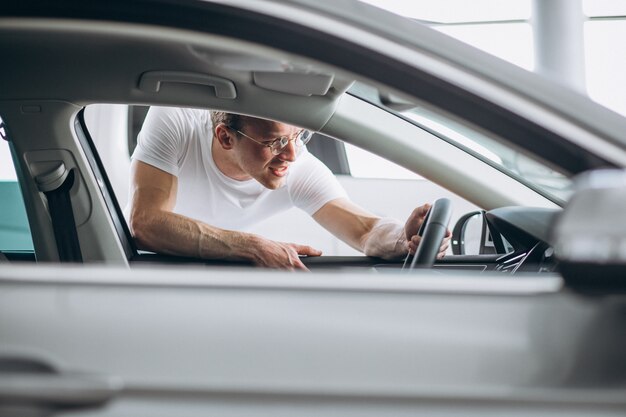 Hombre buscando un coche en una sala de exposición de coches.