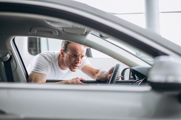 Hombre buscando un coche en una sala de exposición de coches.