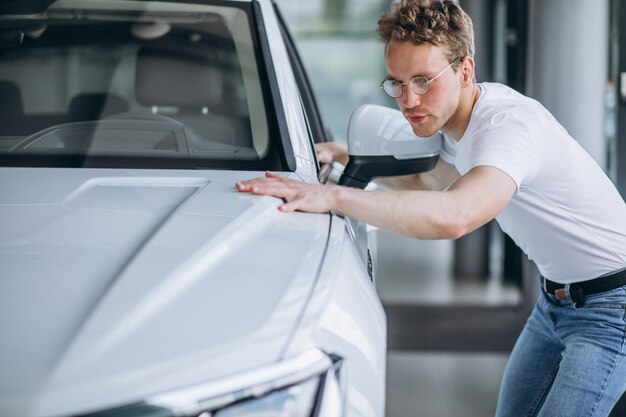 Hombre buscando un coche en una sala de exposición de coches.