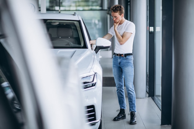 Hombre buscando un coche en una sala de exposición de coches.