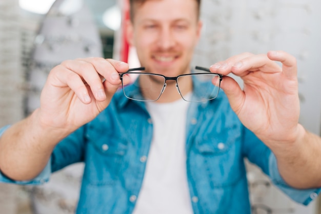 Foto gratuita hombre buscando gafas nuevas en óptico