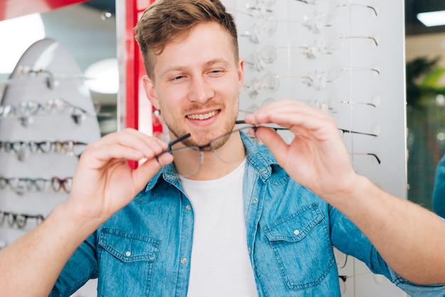 Foto gratuita hombre buscando gafas nuevas en óptico