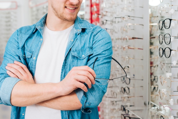 Hombre buscando gafas nuevas en óptico