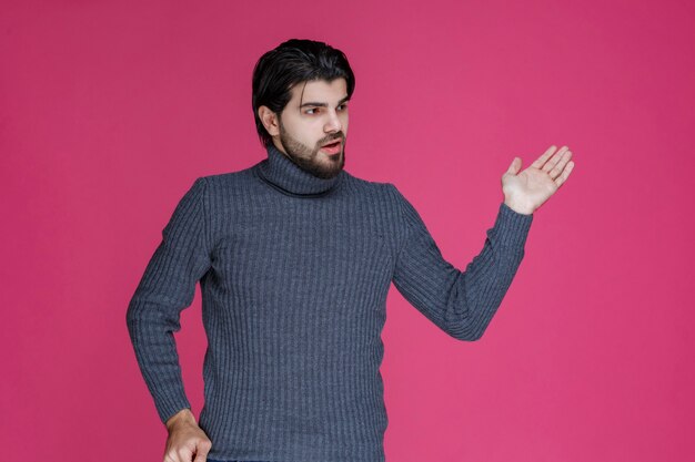 El hombre con cabello largo y barba abre las manos y parece confundido o inexperto.