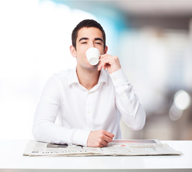 Hombre con un café y un periódico