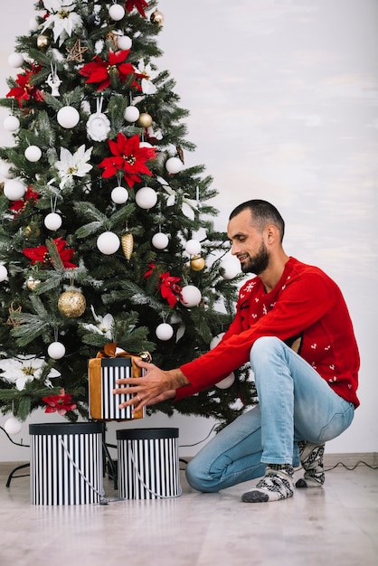 Foto gratuita hombre con caja actual cerca de abeto