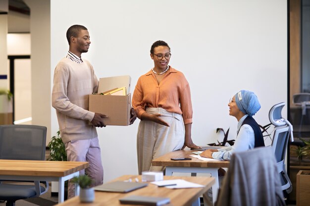 Hombre con caja de pertenencias que se presenta a compañeros de trabajo en su nuevo trabajo