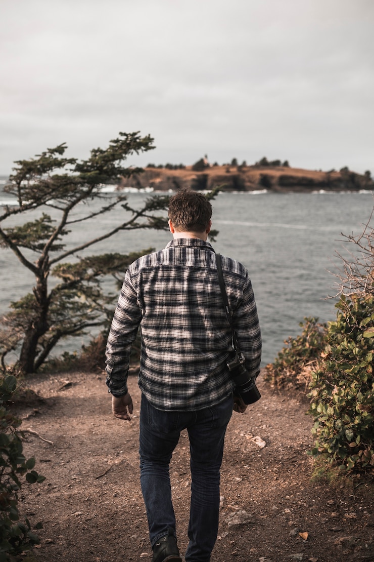 Foto gratuito hombre con cámara caminando hacia el río