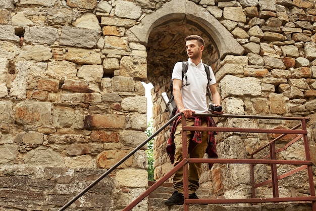 Foto gratuita hombre con cámara en las escaleras del castillo