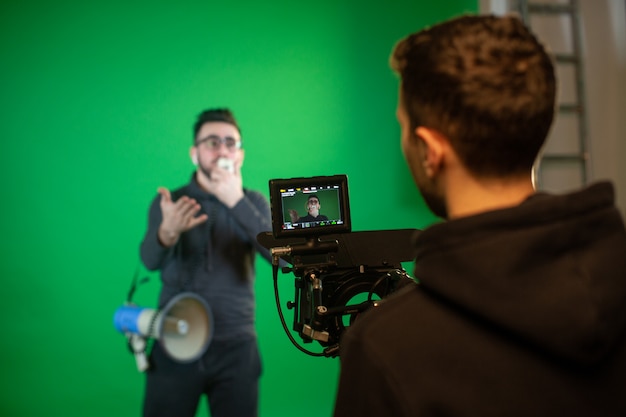 Foto gratuita el hombre de la cámara filma al tipo con altavoz en cámara