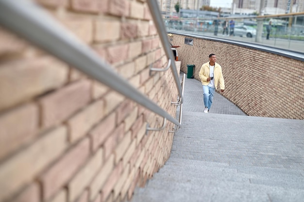 Hombre con cámara subiendo escaleras mirando al lado