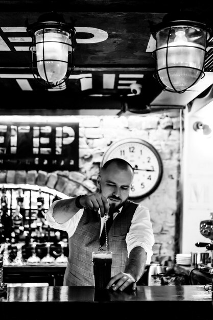 Hombre camarero en el trabajo El camarero mezcla cócteles