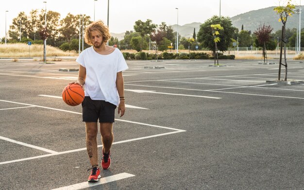 Hombre caminando con el baloncesto en la cancha