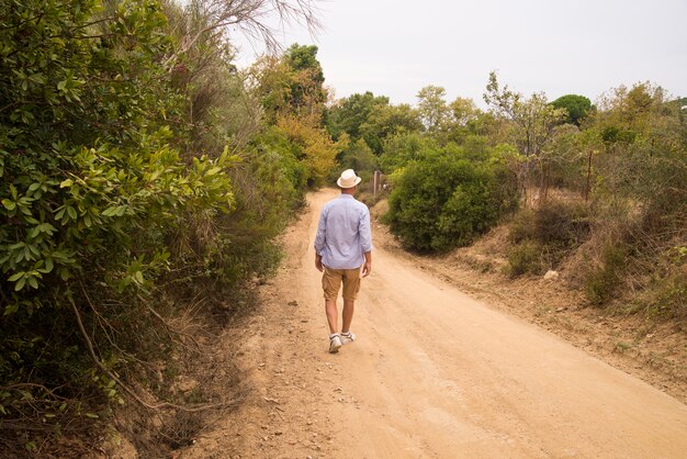 Hombre caminando en la carretera con relajar el estado de ánimo.