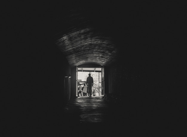 Hombre caminando hacia la luz al final de un túnel