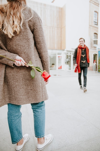 Hombre caminando a mujer con rosa