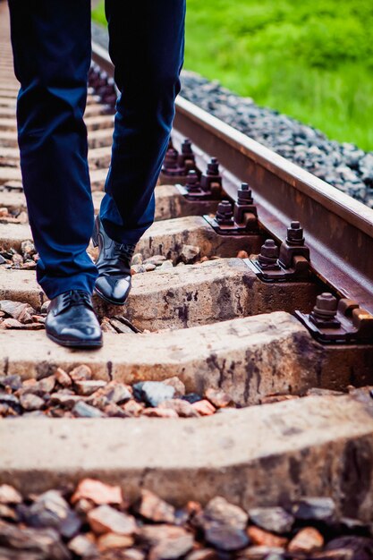 El hombre caminando sobre los durmientes del ferrocarril