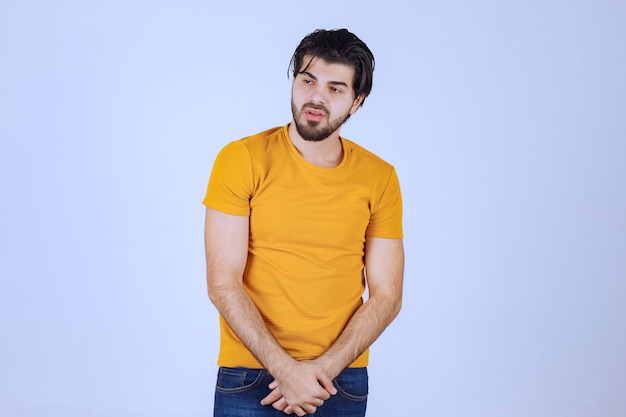Hombre de camisa amarilla dando poses seductoras y atractivas