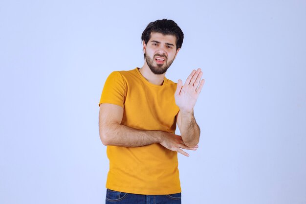 Hombre de camisa amarilla parando algo