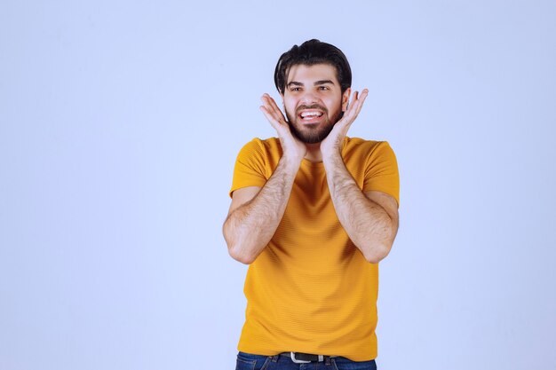 El hombre con camisa amarilla parece asustado y emocionado.