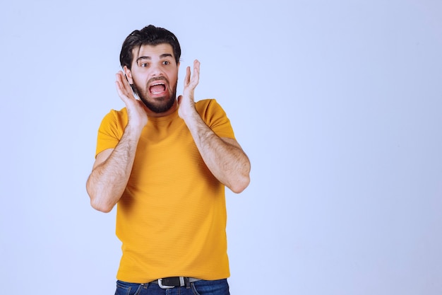 El hombre con camisa amarilla parece asustado y emocionado.