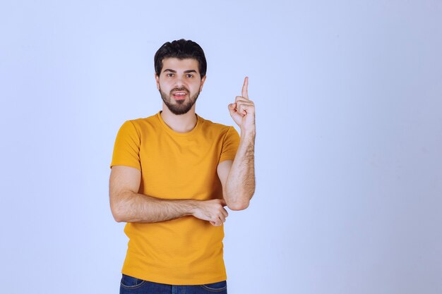 El hombre con camisa amarilla parece dudoso y pensando.