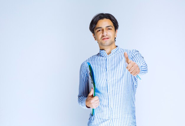 Hombre de camisa azul con carpeta de informes verde. Foto de alta calidad