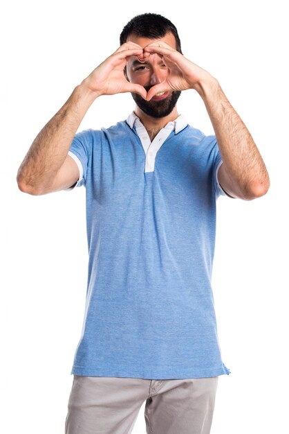 Hombre con camisa azul haciendo un corazón con sus manos