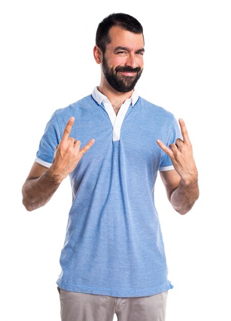 Hombre con la camisa azul que hace gesto del cuerno