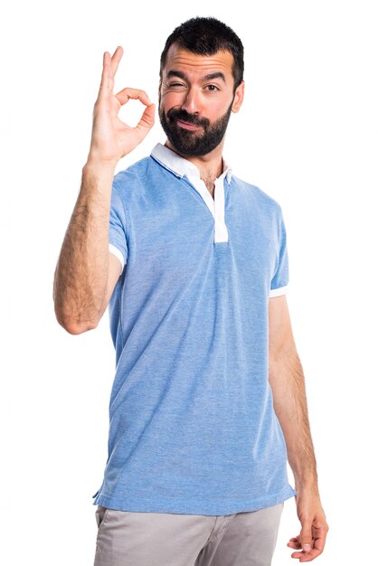 Hombre con la camisa azul que hace la muestra ACEPTABLE